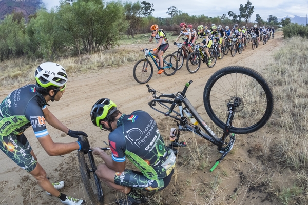 Miguel Angel Hidalgo and Juan Busso repair a puncture as the lead ladies pass during stage 6 of the 2016 Absa Cape Epic Mount ain Bike stage race from Boschendal in Stellenbosch, South Africa on the 19th March 2015 Photo by Dominic Barnardt/Cape Epic/SPORTZPICS 